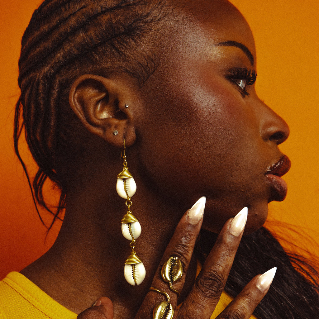Boucles d'oreilles pendantes à trois coquillages cauris, portées